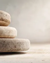Minimal stacked stone forms symbolizing balance, stability, and gradual accumulation over time on a neutral background.
