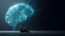 A man sitting and reading in a dark space, with a large glowing brain made of light particles above him, representing brain energy and cognitive function.